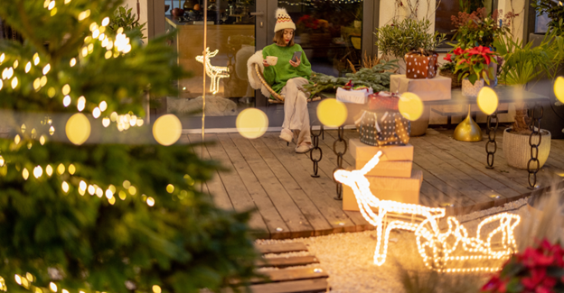 A person sitting on a porch with lights